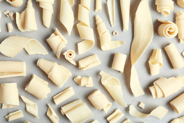 White chocolate curls on gray background, top view