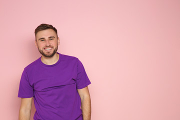 Obraz premium Portrait of young man laughing on color background. Space for text