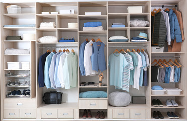 Stylish clothes, shoes and home stuff in large wardrobe closet