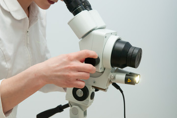 Closeup woman gynecologist working with colposcope