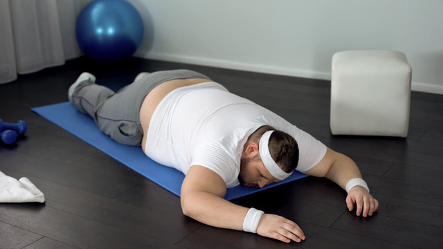 Unmotivated Man Lying On Mat, Giving Up During Exhausted Muscles Training