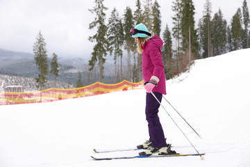 Female skier on slope at resort. Winter vacation