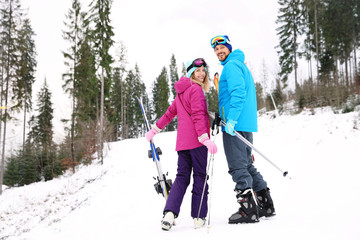 Couple of skiers on slope at resort. Winter vacation