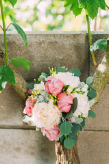 The bouquet of peonies on a wooden background.