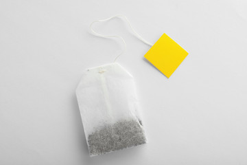 Unused tea bag with tag on white background, top view. Space for text