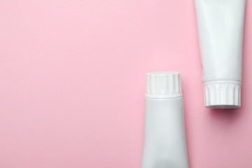Blank tubes of toothpaste on color background, top view with space for text