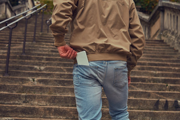 Modern man using cellphone in European city.