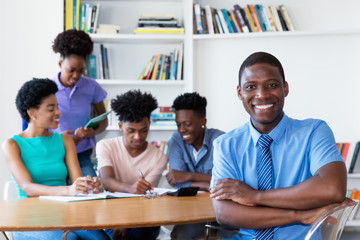 Handsome african male teacher with class at school