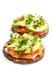 Salmon and avocado rye bread sandwich isolated on white