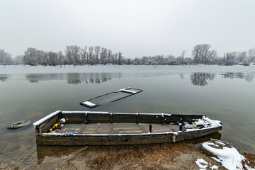 Naklejka premium Danube island (Šodroš) near Novi Sad, Serbia. Colorful landscape with snowy trees, beautiful frozen river. A boats covered with snow or submerged.