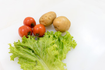 Tomato potato and lettuce isolated on white background with copy space. Healthy vegetables and herbs concept.