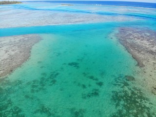 Aerial view of shades of blue and coral reefs over the Moorea lagoon in French Polynesia, South Pacific