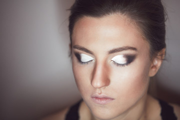 Naklejka premium Young beautiful woman applying make-up by make-up artist. Process of making makeup.