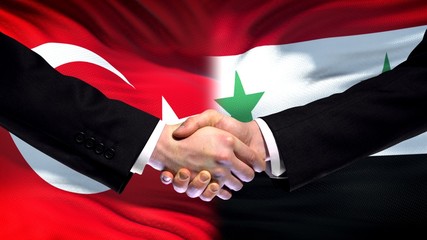 Turkey and Syria handshake, international friendship relations, flag background