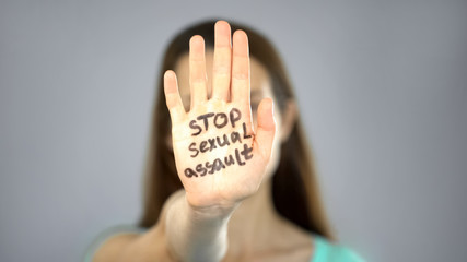 Stop sexual assault sign on womans hand, female rights protection, awareness