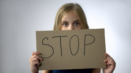 Girl shows stop sign, social protection of children domestic violence prevention