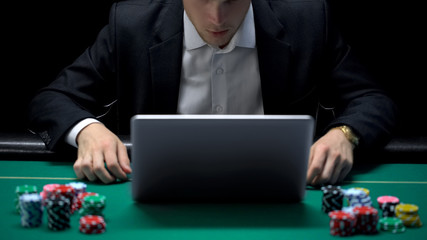 Naklejka premium Gambling addicted businessman in front of laptop, losing sport bet, bankrupt