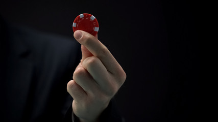 Businessman hand holding casino chip, tycoon making risky investment decision