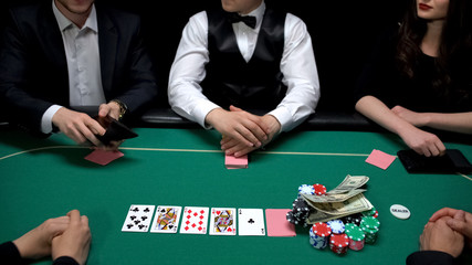 Rich poker player checking wallet, wants to raise bets, casino gambling bluff