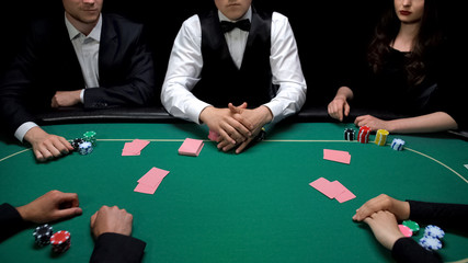Start of poker game at green table, players ready to check cards combinations