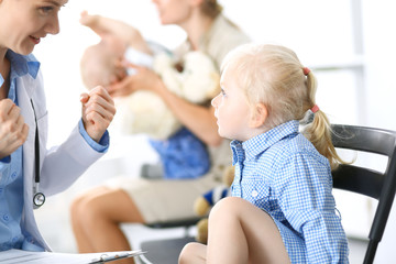 Doctor and a little blonde girl. Usual health exam. Medicine and healthcare concept