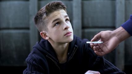 Street guy teaching boy to smoke, influence of society on formation of person