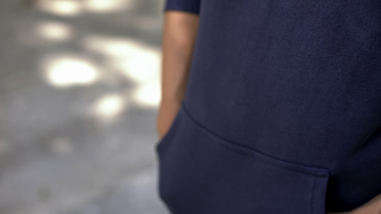 Teen in casual clothes waiting for appointment, hands in pockets, anticipation