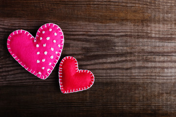 Red felt hearts on a wooden table. Handmade blank for cards, copy space.