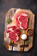Raw marbled ribeye steak and spices