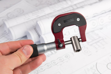 Measurement of metal part with micrometer on engineering drawings