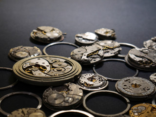 Mechanisms of watches and their parts on a black background