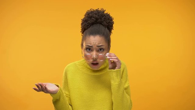 Indignant African-American lady looking through eyeglasses, unfair decision