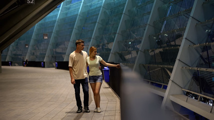 Young couple walking near stadium, waiting for football match, common interests