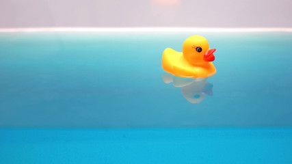 Yellow rubber duck floating in bath, relaxing time for children, macro shot