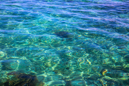 Turquoise blue tropical sea water texture. Seawater closeup photo. Still sea surface. Transparent water of tropical seaside