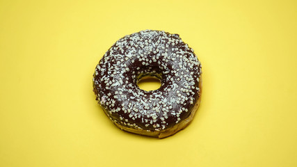 Chocolate glazed donut on yellow background, pastry shop, sweet tasty snack