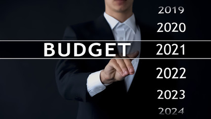2021 budget, businessman selects file on virtual screen, annual financial report