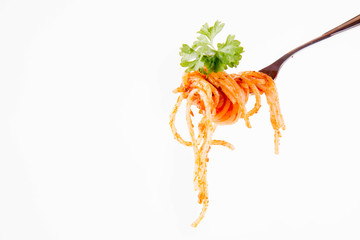 Spaghetti with pesto rosso on a fork decorated with parsley on a white background