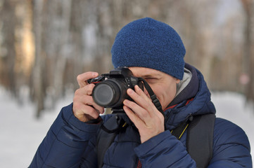 Fototapeta na wymiar A young man takes pictures in the Park in winter.