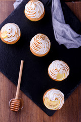 Fototapeta na wymiar Lemon muffins with protein cream on a slate board with powdered sugar and honey