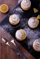 Lemon muffins with protein cream on a slate board with powdered sugar and honey