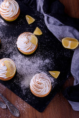 Lemon muffins with protein cream on a slate board with powdered sugar and honey