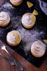 Lemon muffins with protein cream on a slate board with powdered sugar and honey