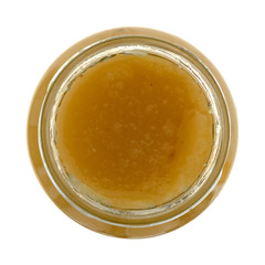 Applesauce in an open glass jar isolated on a white background top view