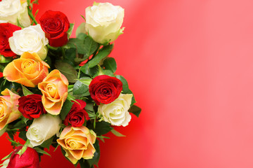 Bouquet of beautiful roses with water drops on a red background 