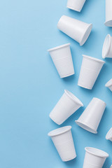 Single use white plastic cups on a blue background