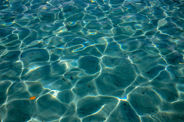 Blue tropical sea water texture. Clean seawater closeup photo. Still sea surface. Transparent water of tropical seaside