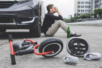 Obraz na płótnie Canvas Image of shocked and scared driver after accident involved Kid's bike and helmet lying on the road on pedestrian crossing after accident collision with drunk car driver