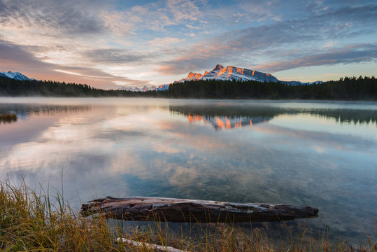 Scenic view of Two Jake Lake against cloudy sky during sunrise