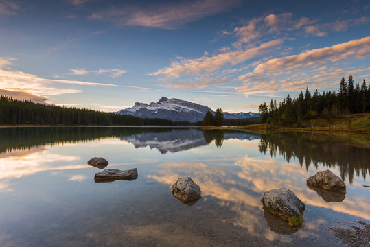 Scenic view of Two Jake Lake against cloudy sky during sunrise